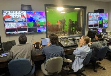 Students in control room producing a TV broadcast program.